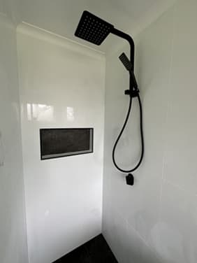 Matte black shower set with niche in a finished bathroom